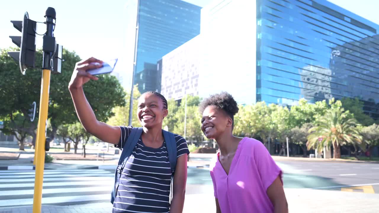 两个女性朋友在探索这座城市时做着鬼脸自拍视频素材