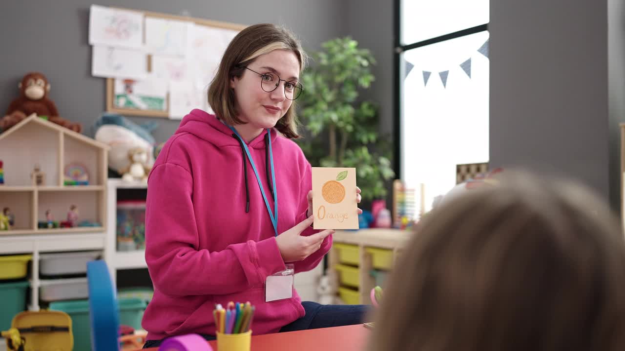 年轻的金发女幼儿园老师在幼儿园上词汇课视频素材