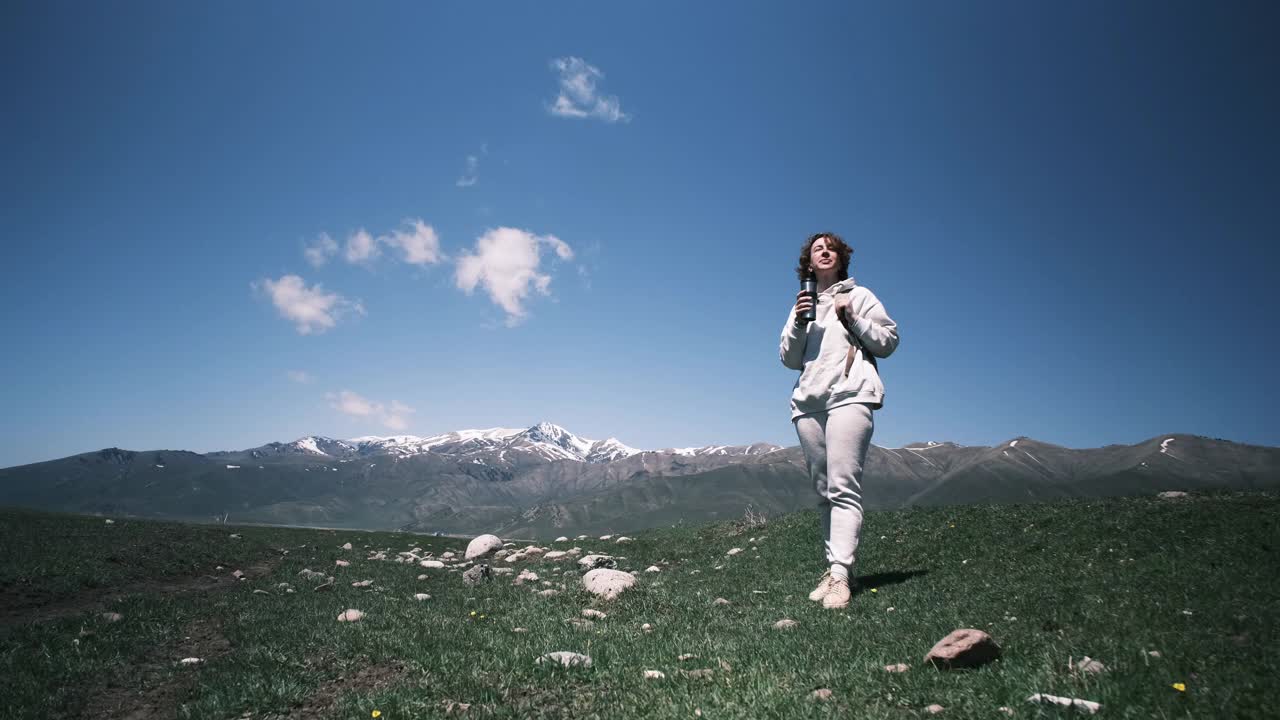 一名女子在山区旅行时用可重复使用的杯子喝水视频素材