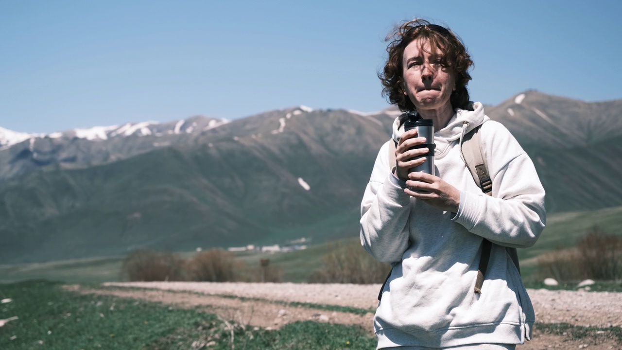 一名女子在山区旅行时用可重复使用的杯子喝水视频素材