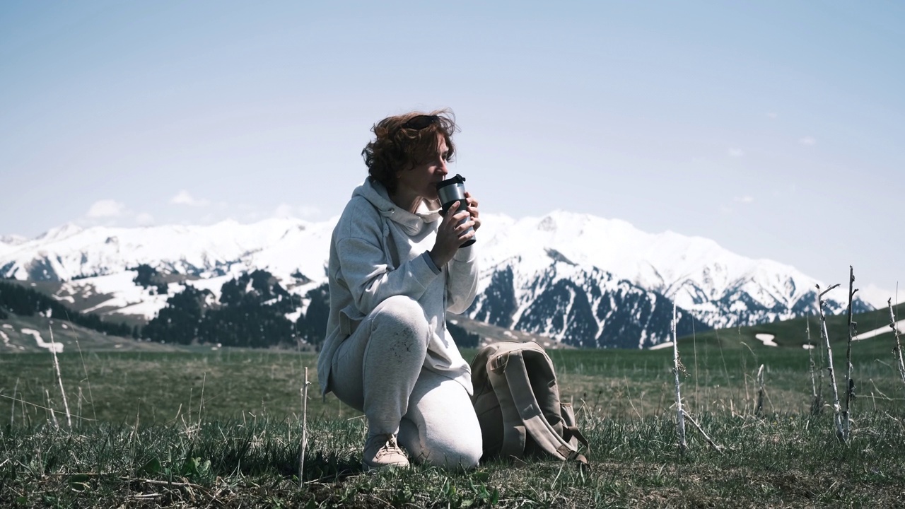 一名女子在山区旅行时用可重复使用的杯子喝水视频素材