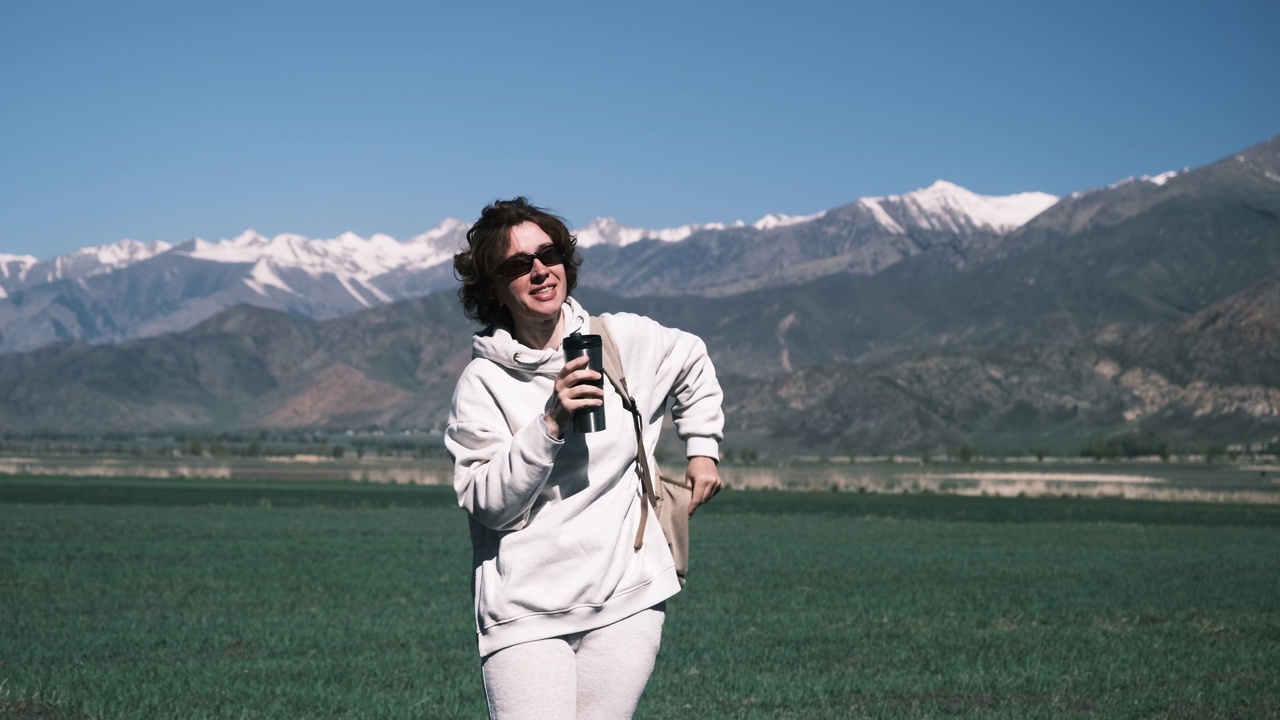 一名女子在山区旅行时用可重复使用的杯子喝水视频素材