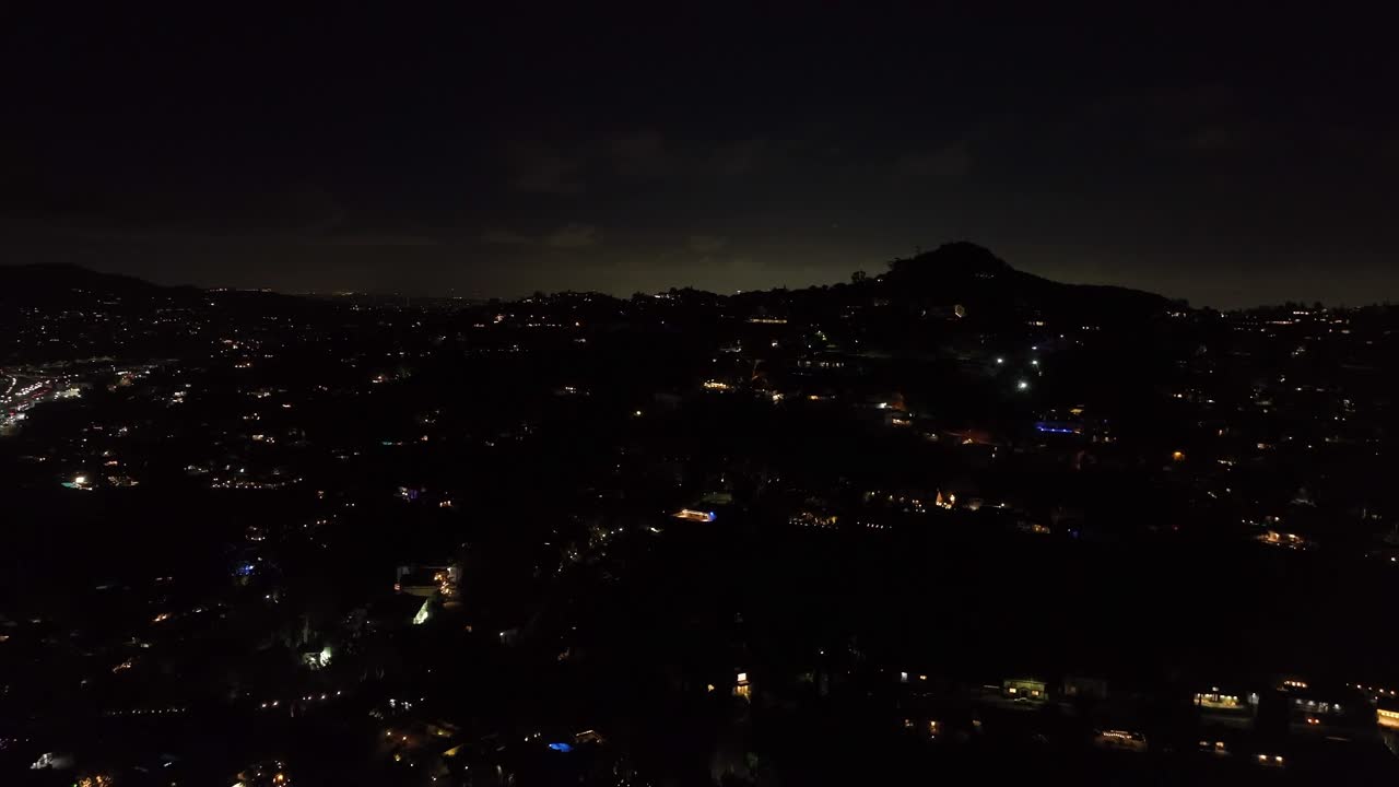 夜间，飞机在市区上空飞行。揭示大都市在云层上发光的全景。洛杉矶，加利福尼亚，美国视频素材