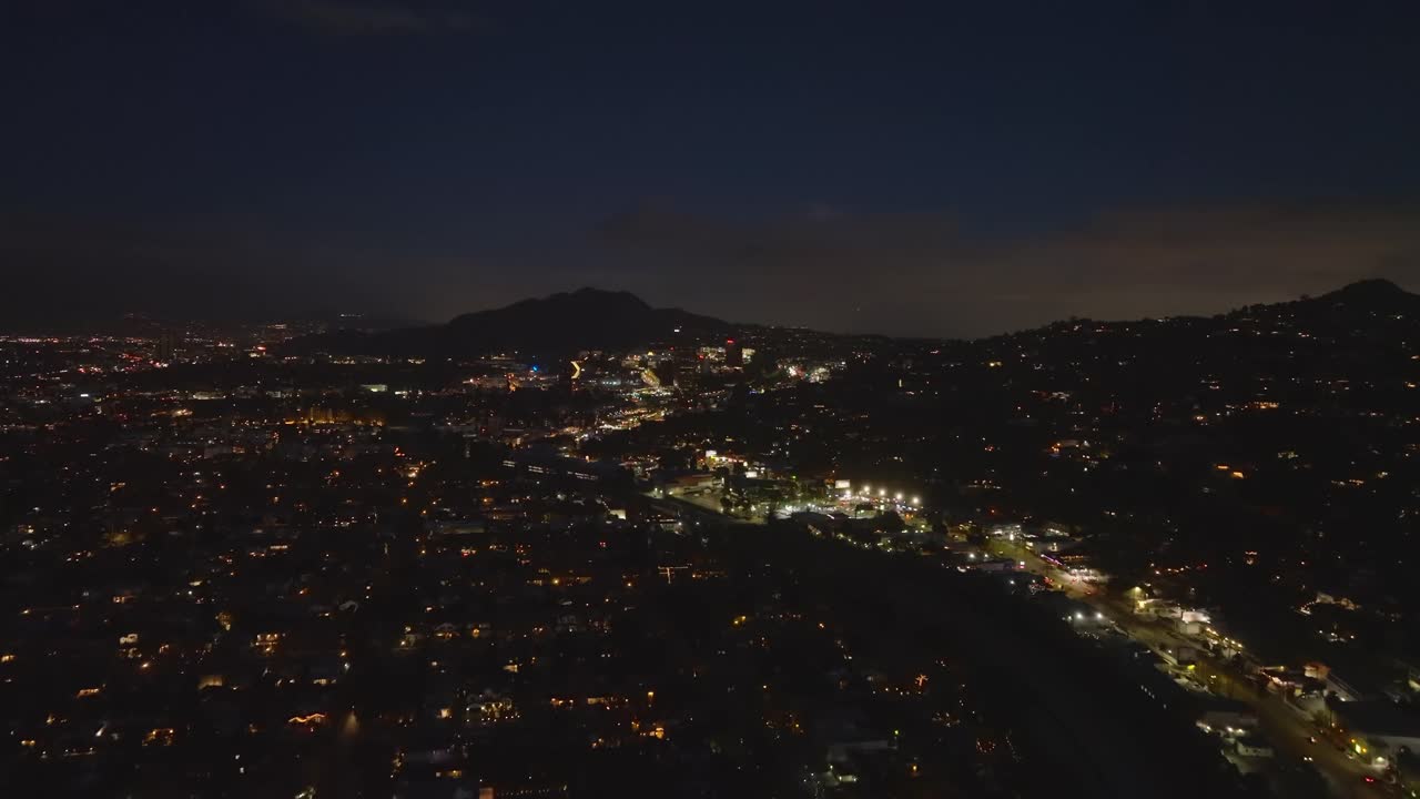 傍晚大城市的鸟瞰图。灯火通明的街道和建筑物，天空映衬出小山的剪影。洛杉矶，加利福尼亚，美国视频素材