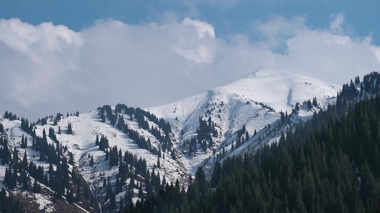 朵朵白云，美丽地飘过白雪覆盖的山峰，一道美丽的山景视频素材