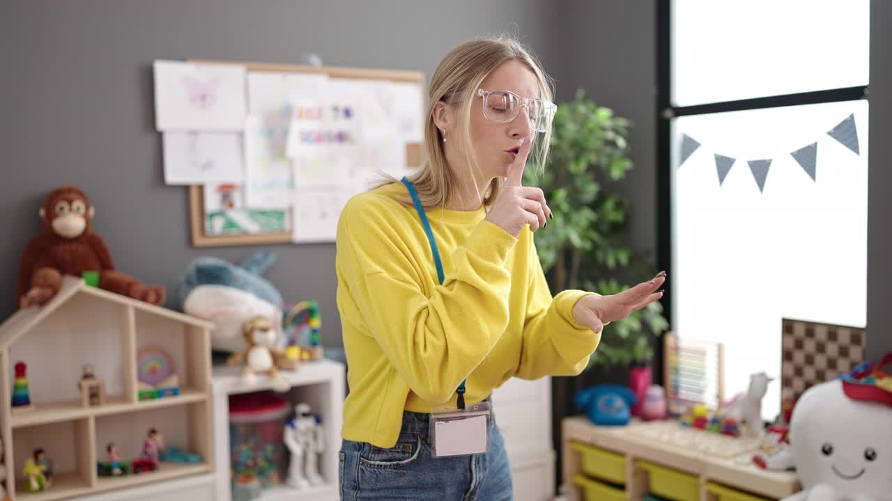 年轻的金发女幼儿园老师要求幼儿园保持安静视频素材