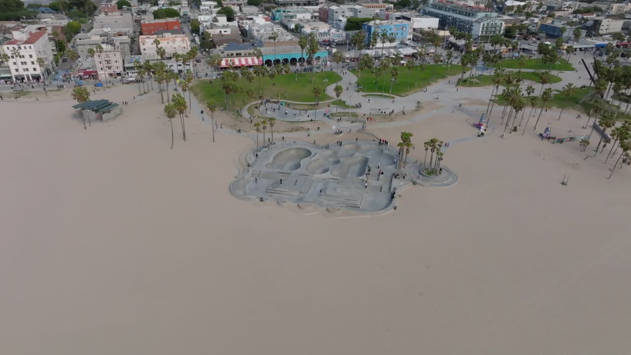 威尼斯海滩上的巨型混凝土滑板公园的空中滑梯和全景镜头。享受户外生活的人们。洛杉矶，加利福尼亚，美国视频素材