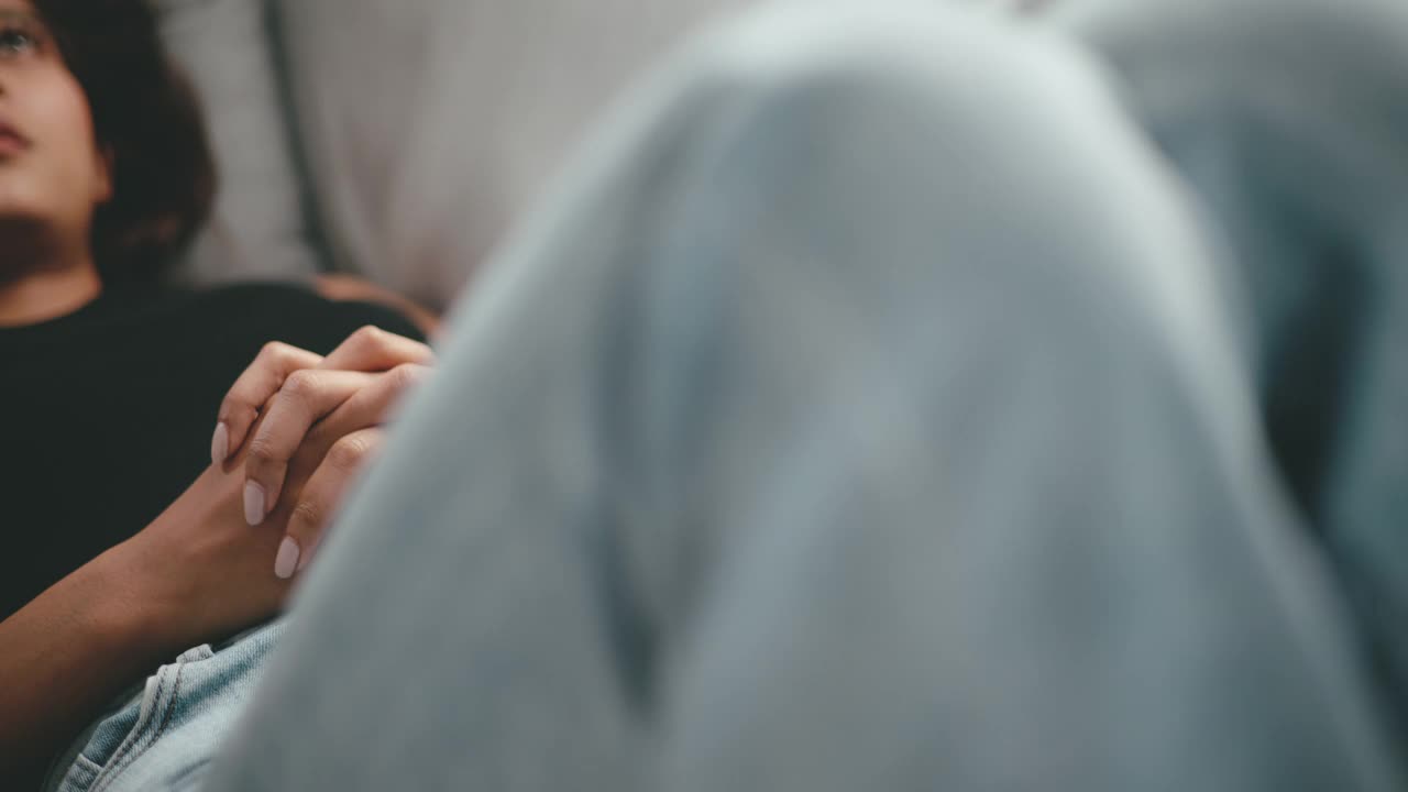 年轻女子躺在沙发上，感到沮丧和沉思的苦恼视频素材