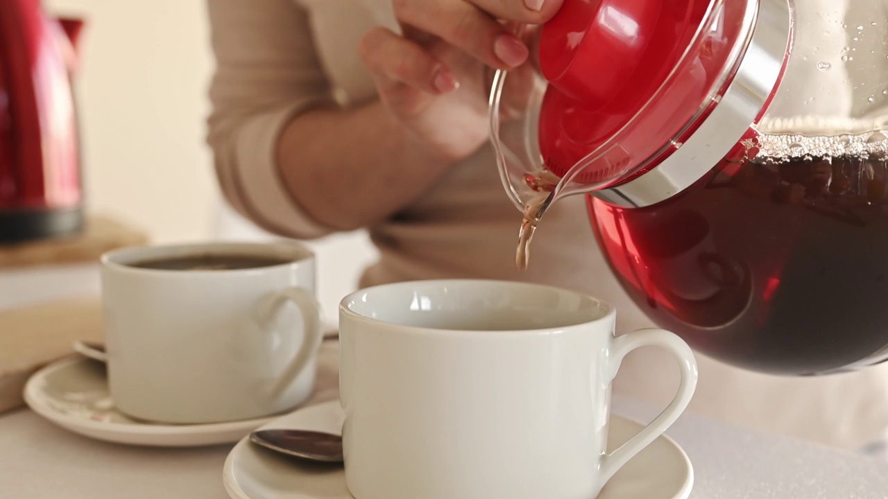 在厨房用茶壶和杯子沏茶视频素材