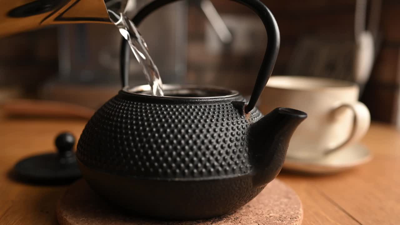 在厨房用茶壶和杯子沏茶视频素材