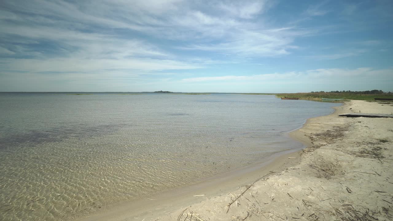 美丽的风景与海岸，海滩，钓鱼木船和岛屿在一个阳光明媚的日子，乌克兰的斯维提亚兹湖。视频素材