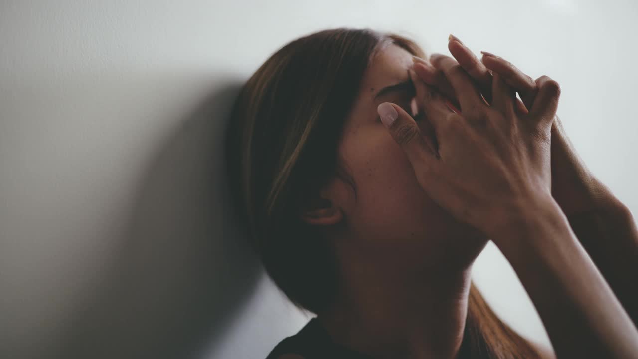 年轻女子坐在与悲伤或焦虑感到心不在焉和沉思视频素材