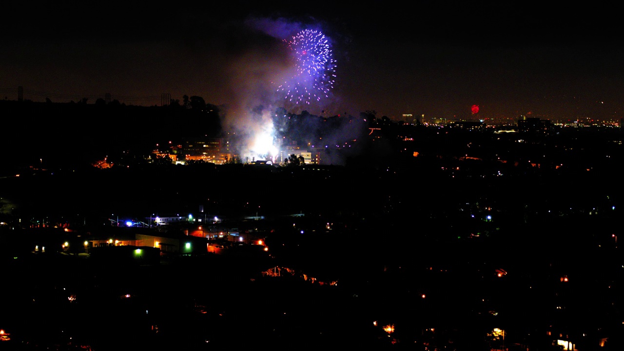 烟花在城市附近爆炸的航拍照片，无人机在城市景观上向前飞行，夜晚对着天空-洛杉矶，加利福尼亚视频素材