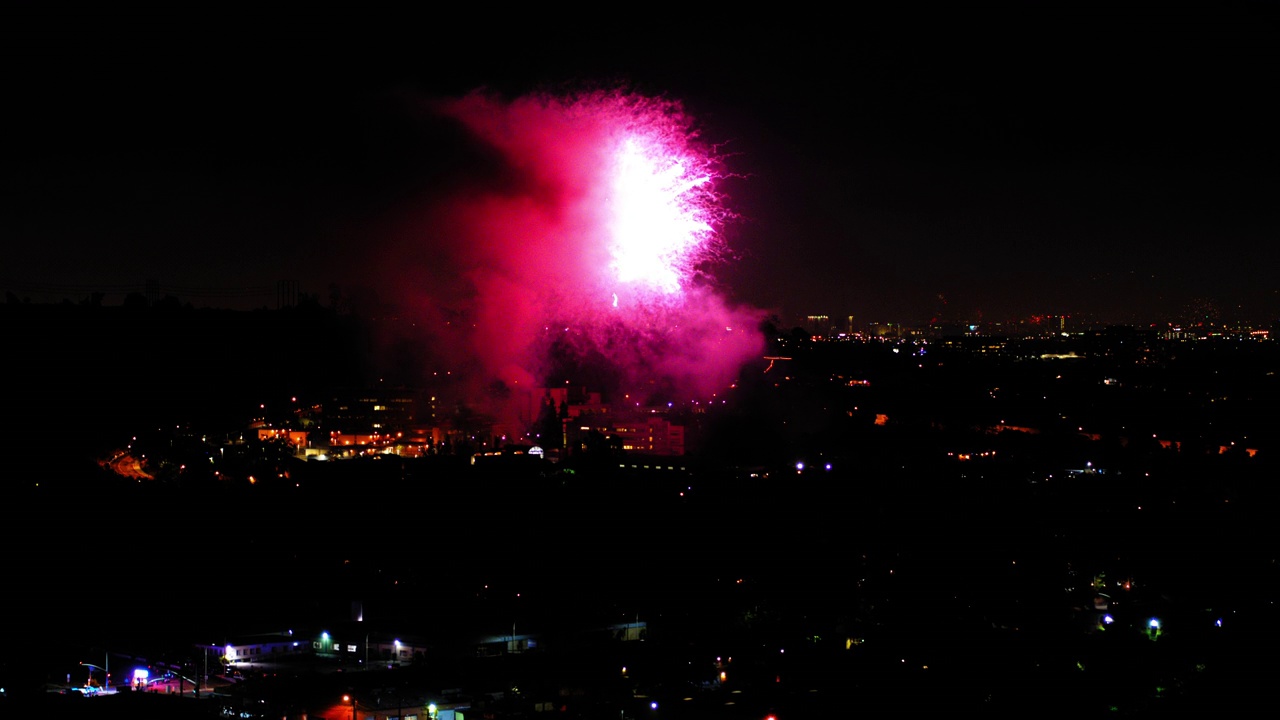 烟花在建筑物上空爆炸的航拍照片，无人机在夜晚飞过城市景观-洛杉矶，加利福尼亚视频素材