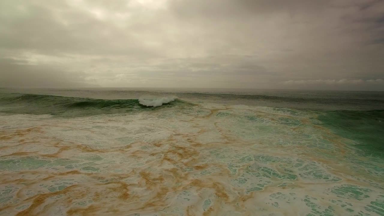 航拍:无人机飞越海浪在海岸上的海岸在沙滩上的多云天空-夏威夷瓦胡岛视频素材