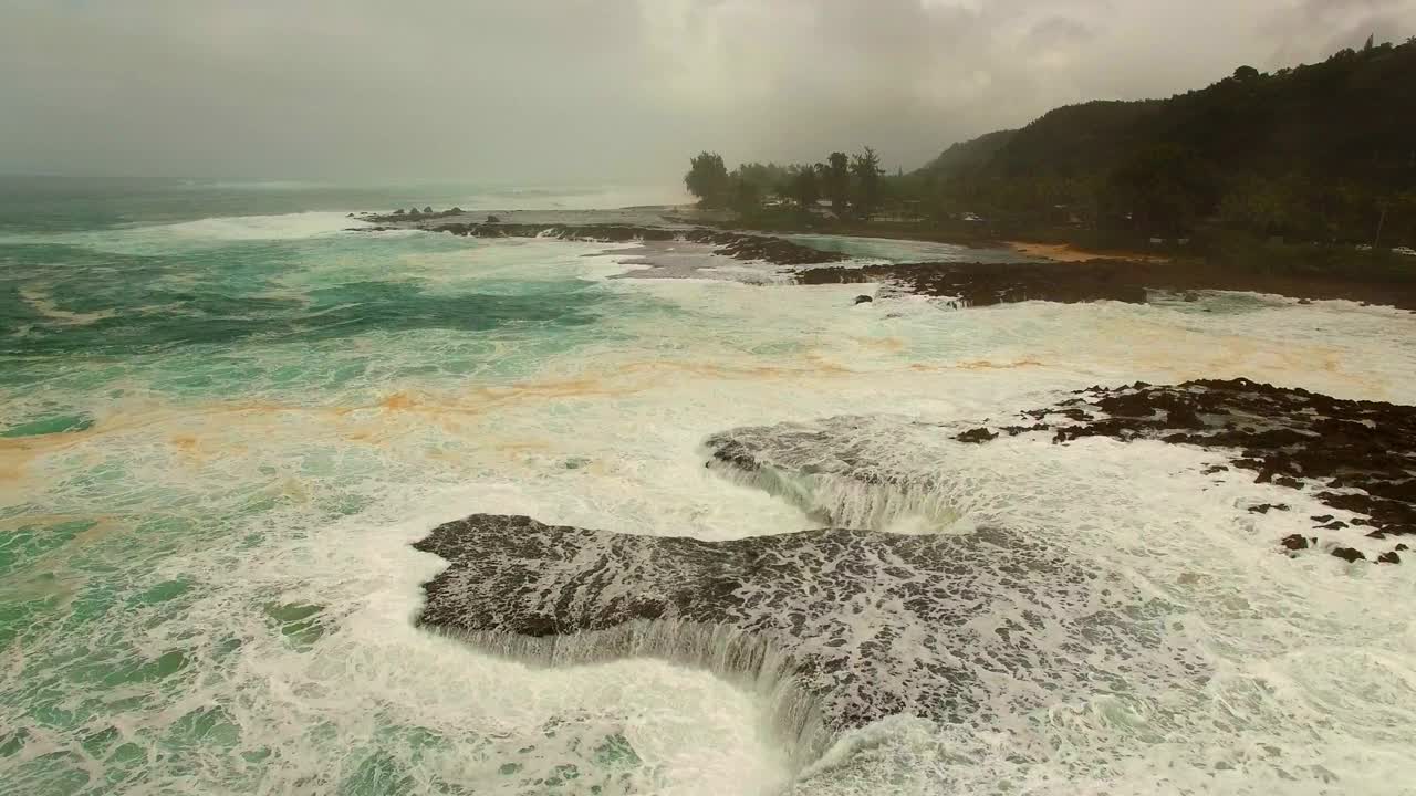 航拍:无人机在日落时在海岸线附近的海上飞溅的海浪上平移-夏威夷瓦胡岛视频素材