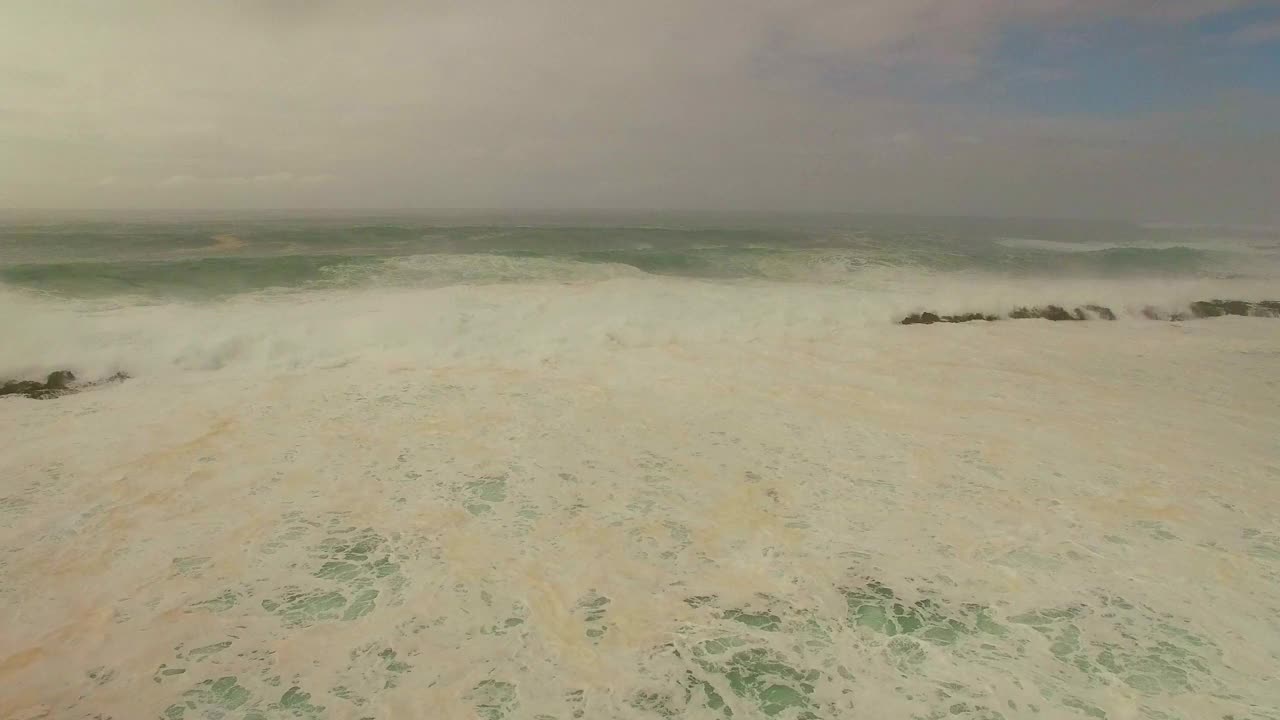 航拍:无人机拍摄的浪花在海上对多云的天空在日落-瓦胡岛，夏威夷视频素材