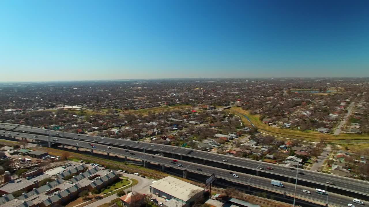 高速公路上的车辆通过社区的航拍镜头，无人机在郊区的房屋上空飞行-德克萨斯州圣安东尼奥视频素材