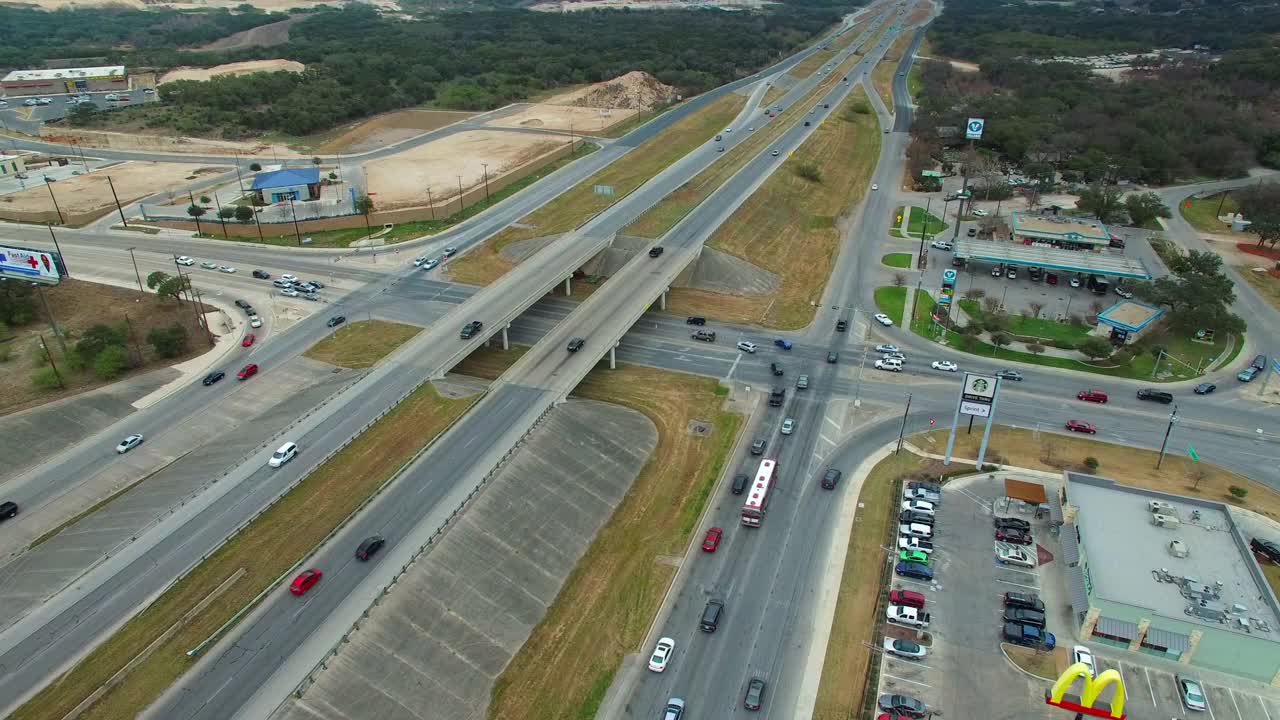 高速公路上的车辆通过树木和建筑物，无人机在城市上空飞行的航拍镜头-德克萨斯州圣安东尼奥视频素材