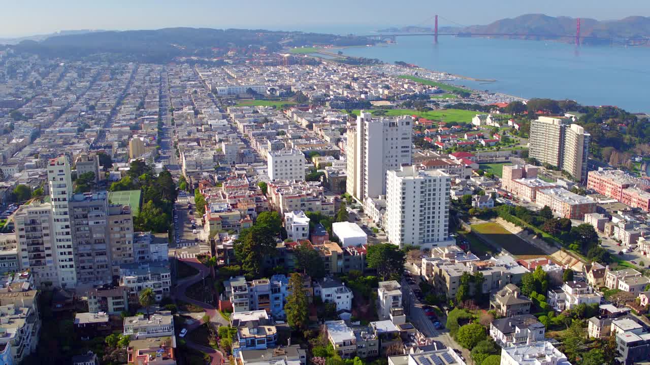 在阳光明媚的日子里，加州旧金山，伦巴第街上的车辆在房屋之间的空中倾斜拍摄，无人机飞越社区视频素材