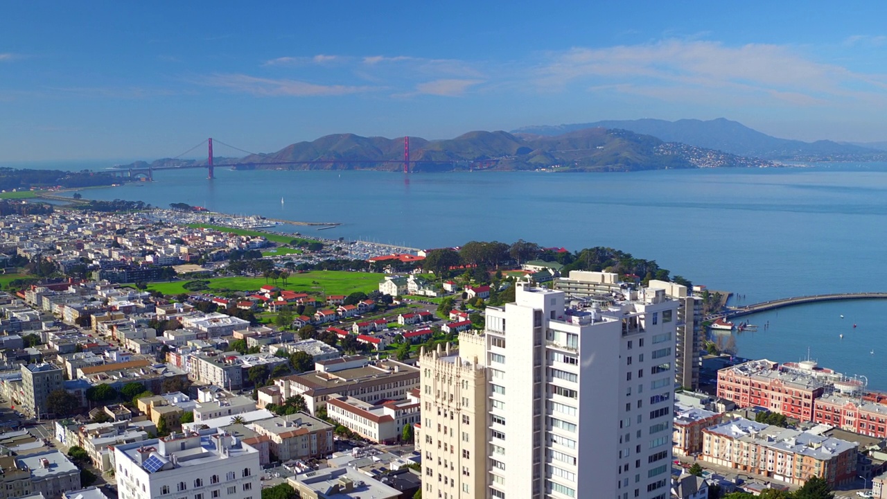 航拍的建筑物附近的船只在海上对天空，无人机飞越城市景观在阳光明媚的一天-旧金山，加利福尼亚视频素材