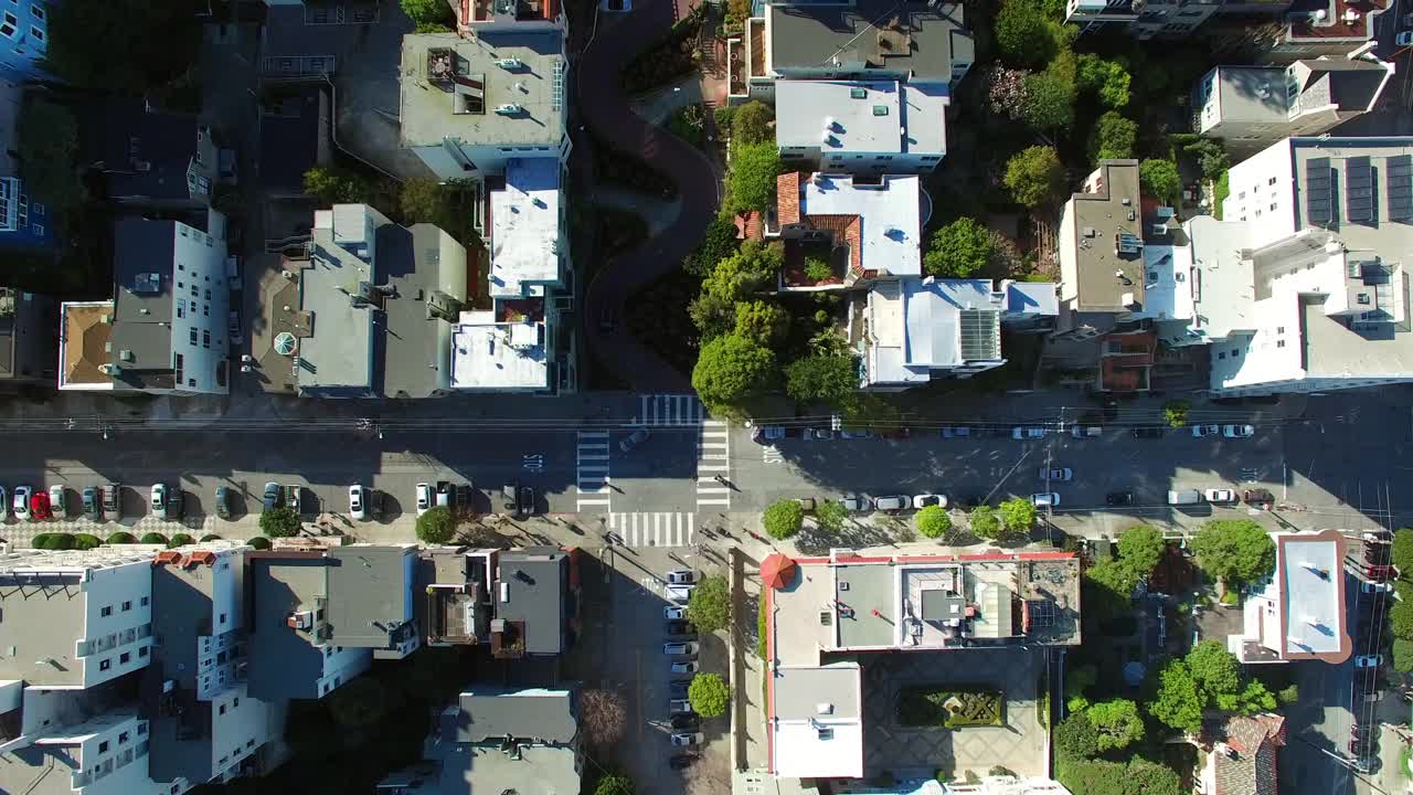 从空中俯瞰伦巴第街，在城市的建筑物中，无人机在阳光明媚的日子里飞过社区-旧金山，加利福尼亚视频素材