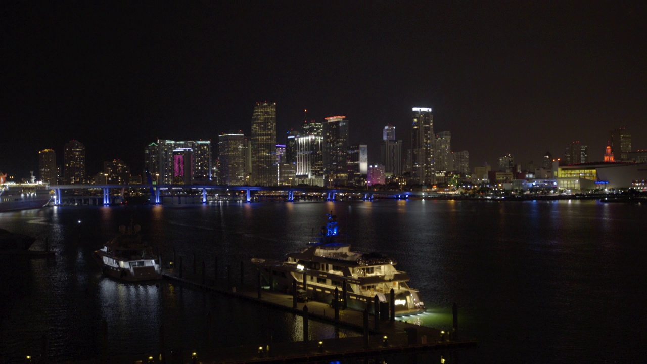 在夜晚，迈阿密，佛罗里达，灯火通明的城市里，被封锁的港口映衬着天空视频素材