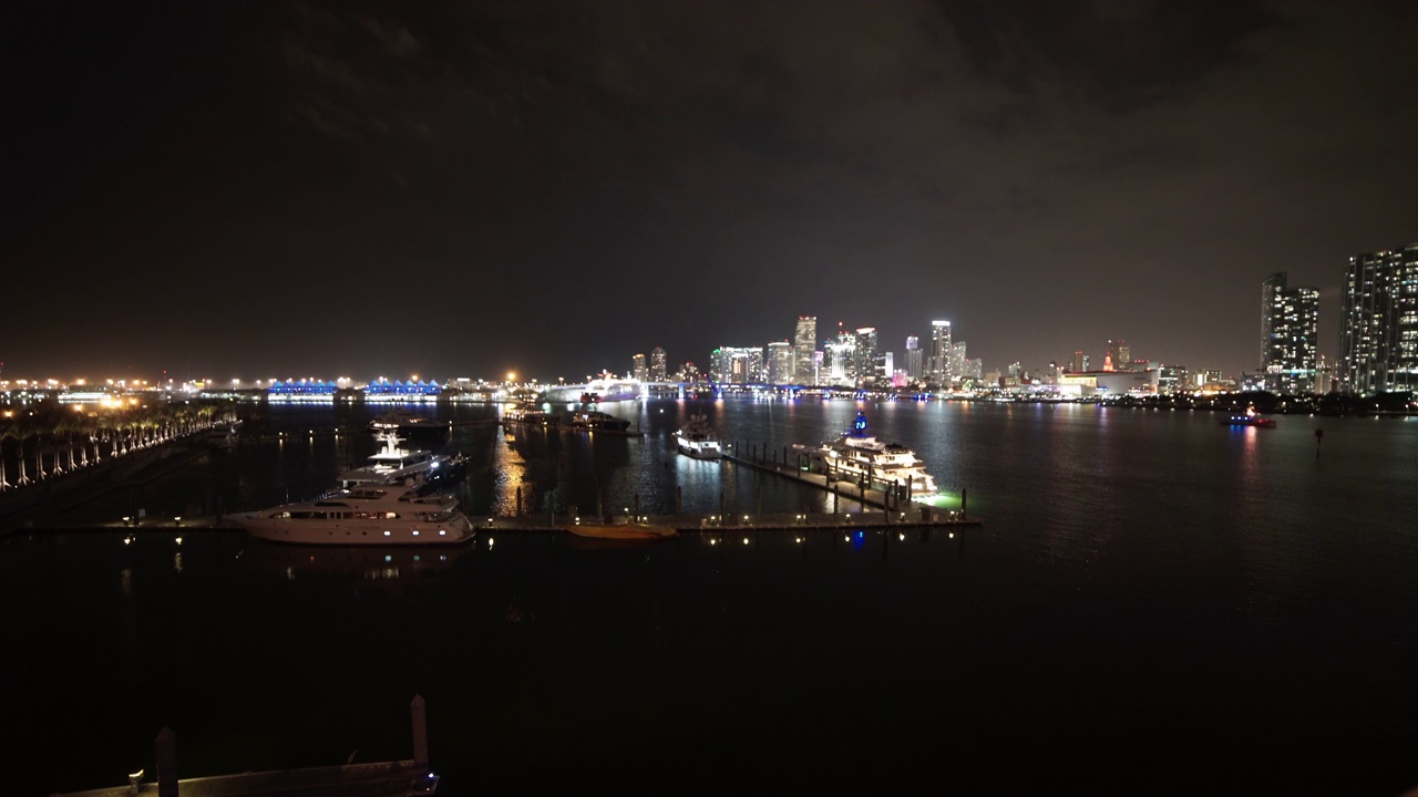 停泊在城市附近港口的游艇在夜晚对着天空的锁定镜头-迈阿密，佛罗里达州视频素材