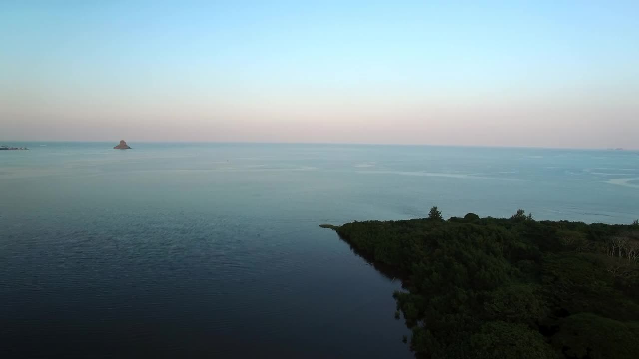 日落时，无人机在夏威夷瓦胡岛上空拍摄的山脉和大海的空中平移镜头视频素材