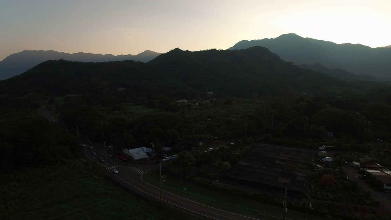 空中拍摄的车辆在道路附近的山脉，无人机下降在景观对天空在日落-瓦胡岛，夏威夷视频素材