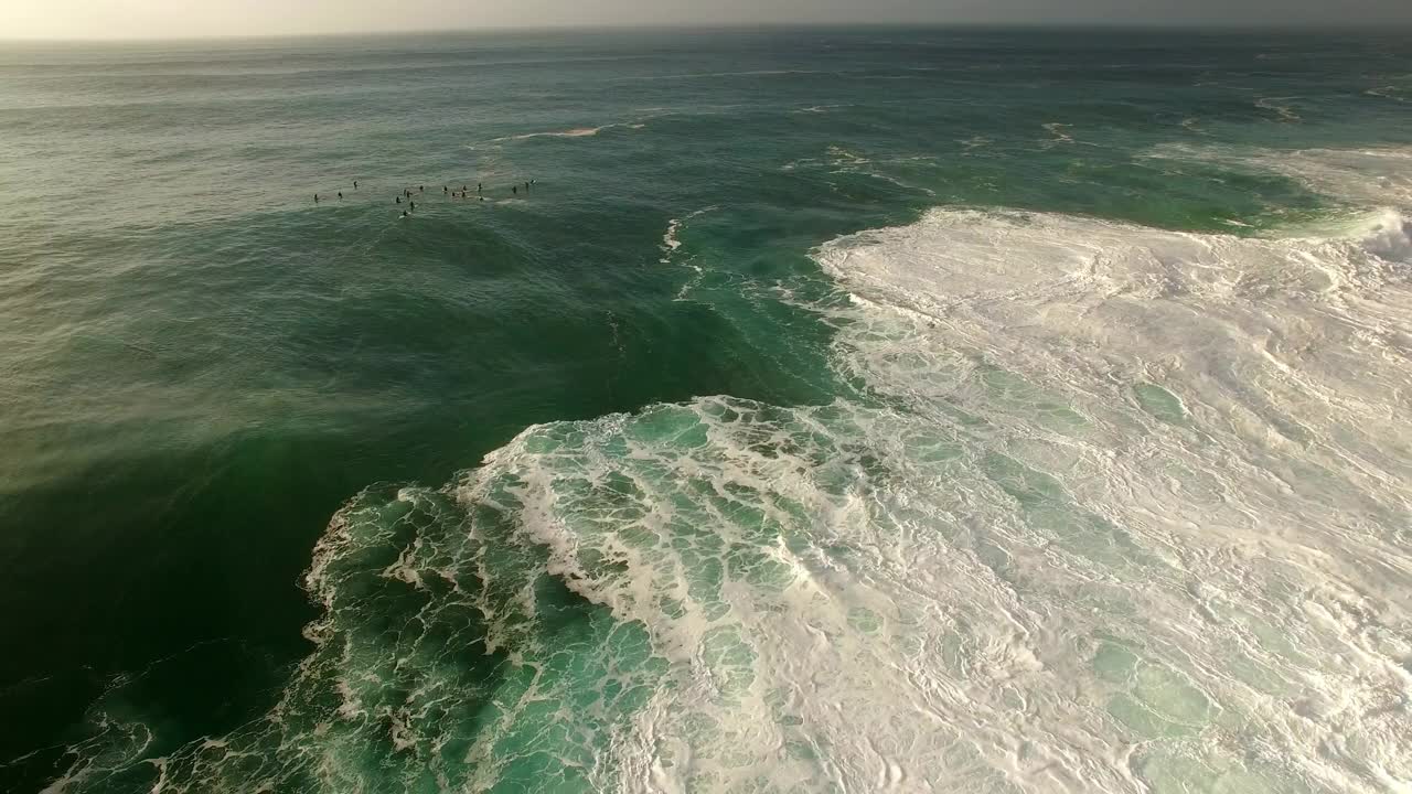 航拍冲浪者在日落时海浪对着天空，无人机在海上飞行-夏威夷瓦胡岛视频素材