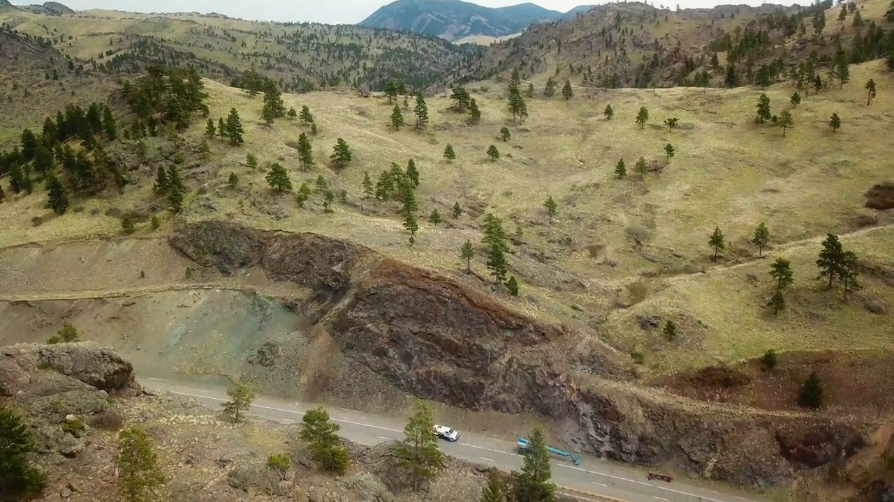 在蒙大拿比林斯山区道路上行驶的车辆的空中倾斜向下拍摄视频素材