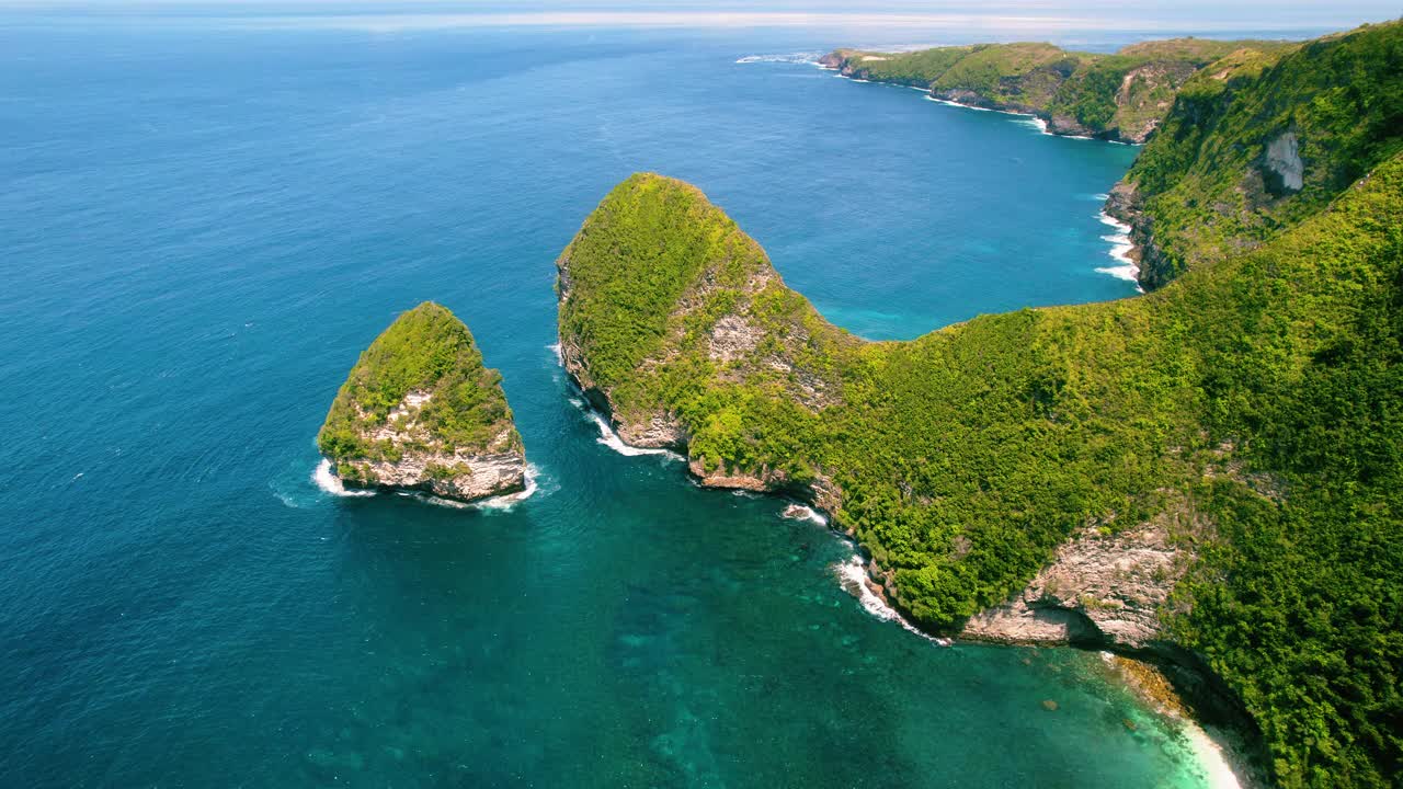 绿色的热带雨林悬崖，可灵景海滩，清澈的海水。印度尼西亚巴厘岛海岸线上的奇异岛屿。视频素材