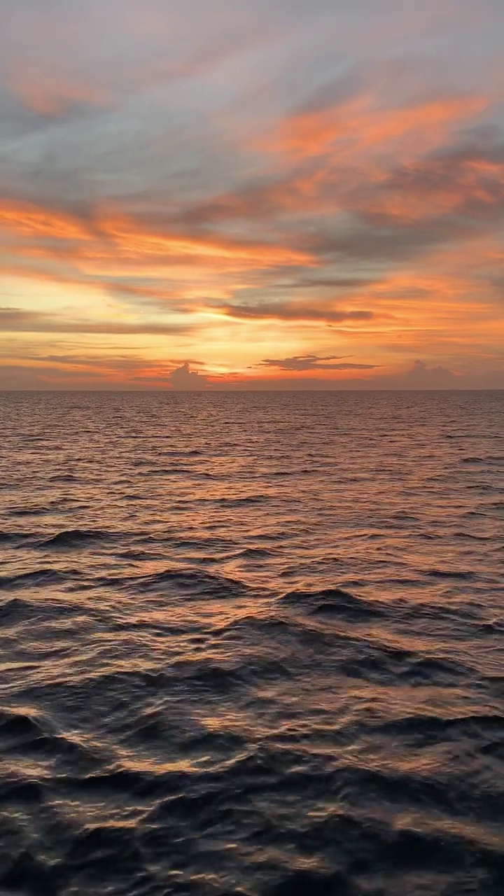 美丽的海景橙色的天空在日落与平静的海浪。海水地平线视频素材