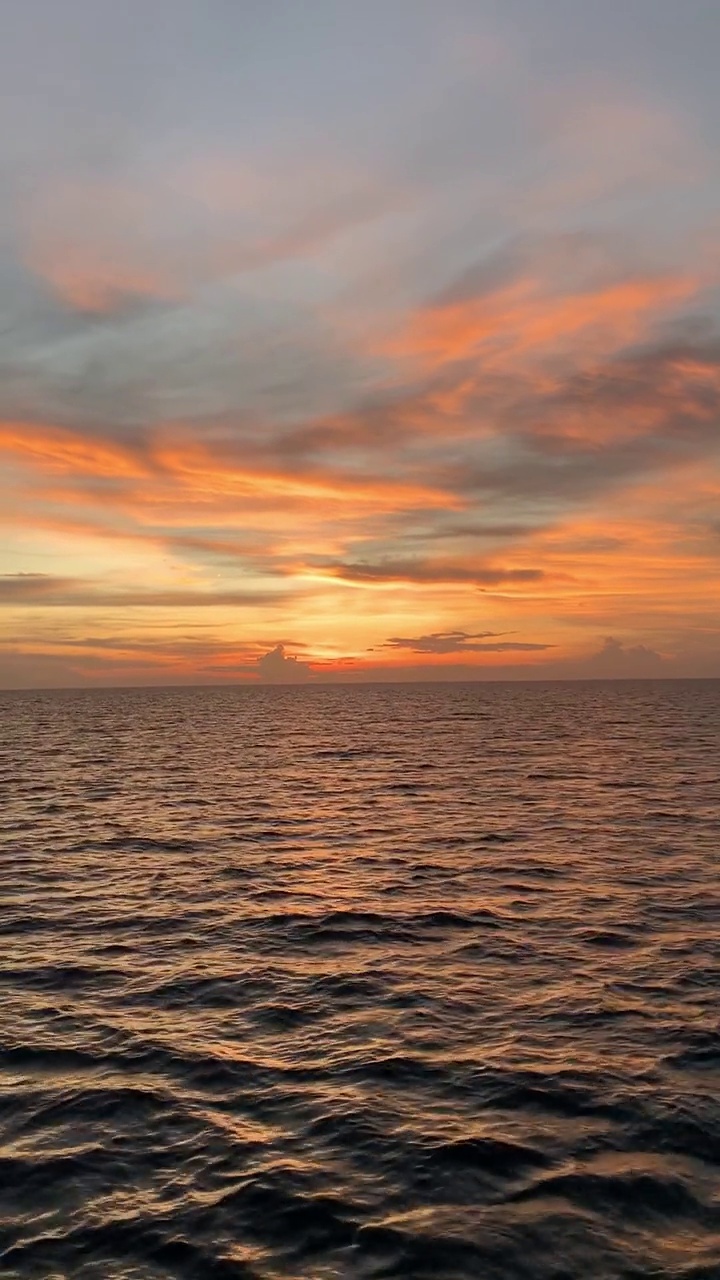 美丽的海景橙色的天空在日落与平静的海浪。海水地平线视频素材