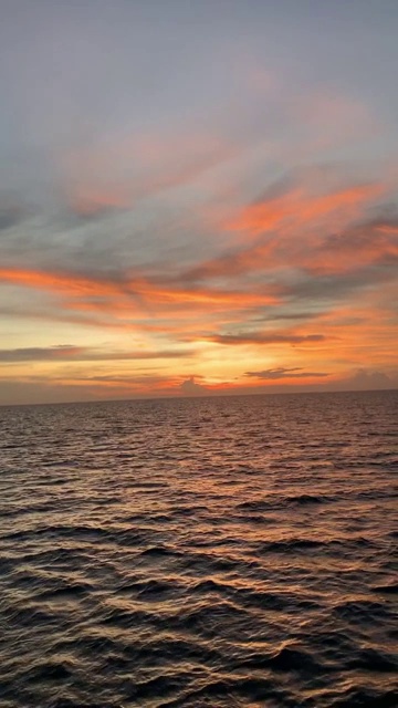 美丽的海景橙色的天空在日落与平静的海浪。海水地平线视频素材