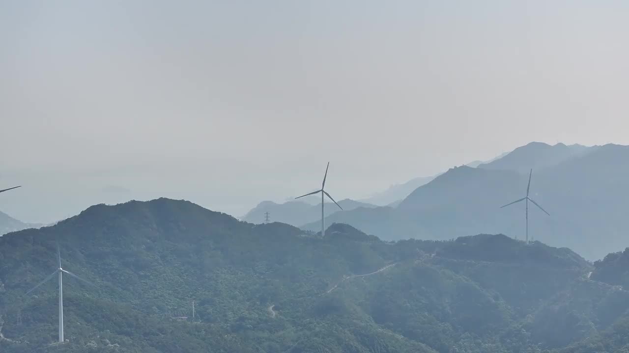 在多雾的海边山顶上有风力发电场视频素材