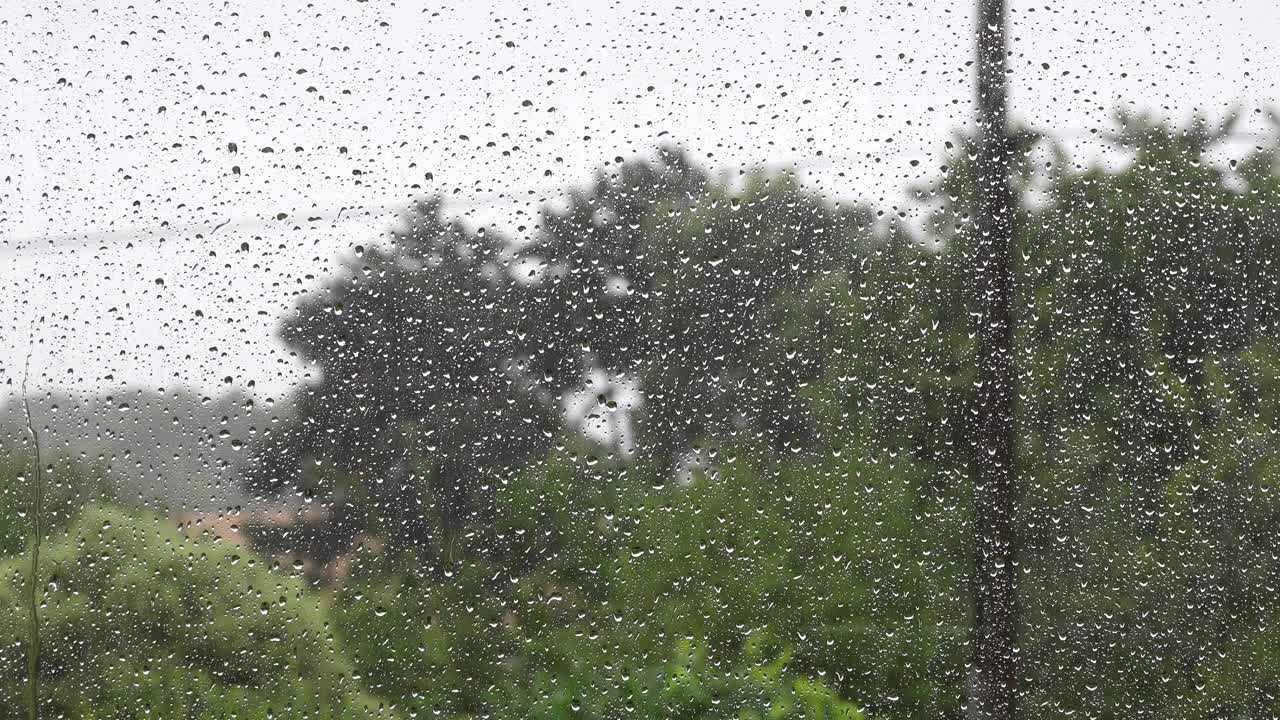 阴雨的天气里，一扇湿漉漉的窗户玻璃后面布满了水珠。视频素材