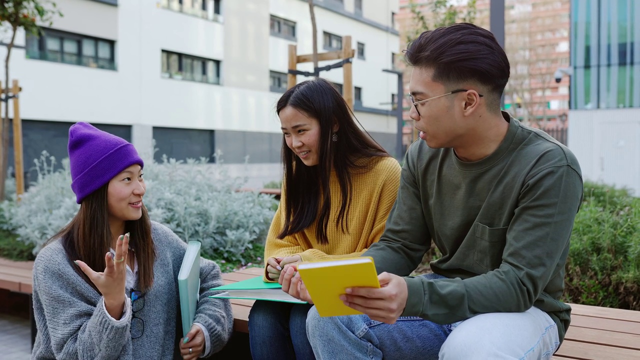 年轻的中国女学生在校园里和她的亚洲同学朋友见面。视频素材