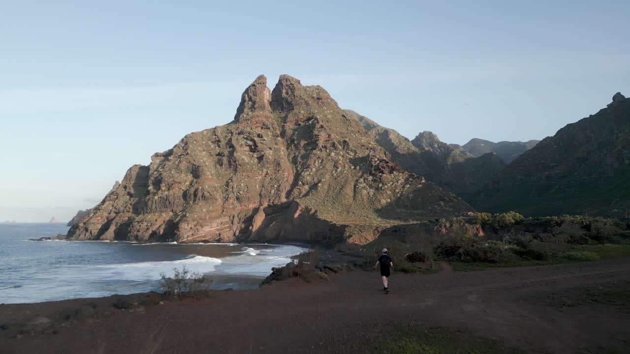 在阳光明媚的日子里，海浪拍打着巨大的悬崖和岩石视频素材