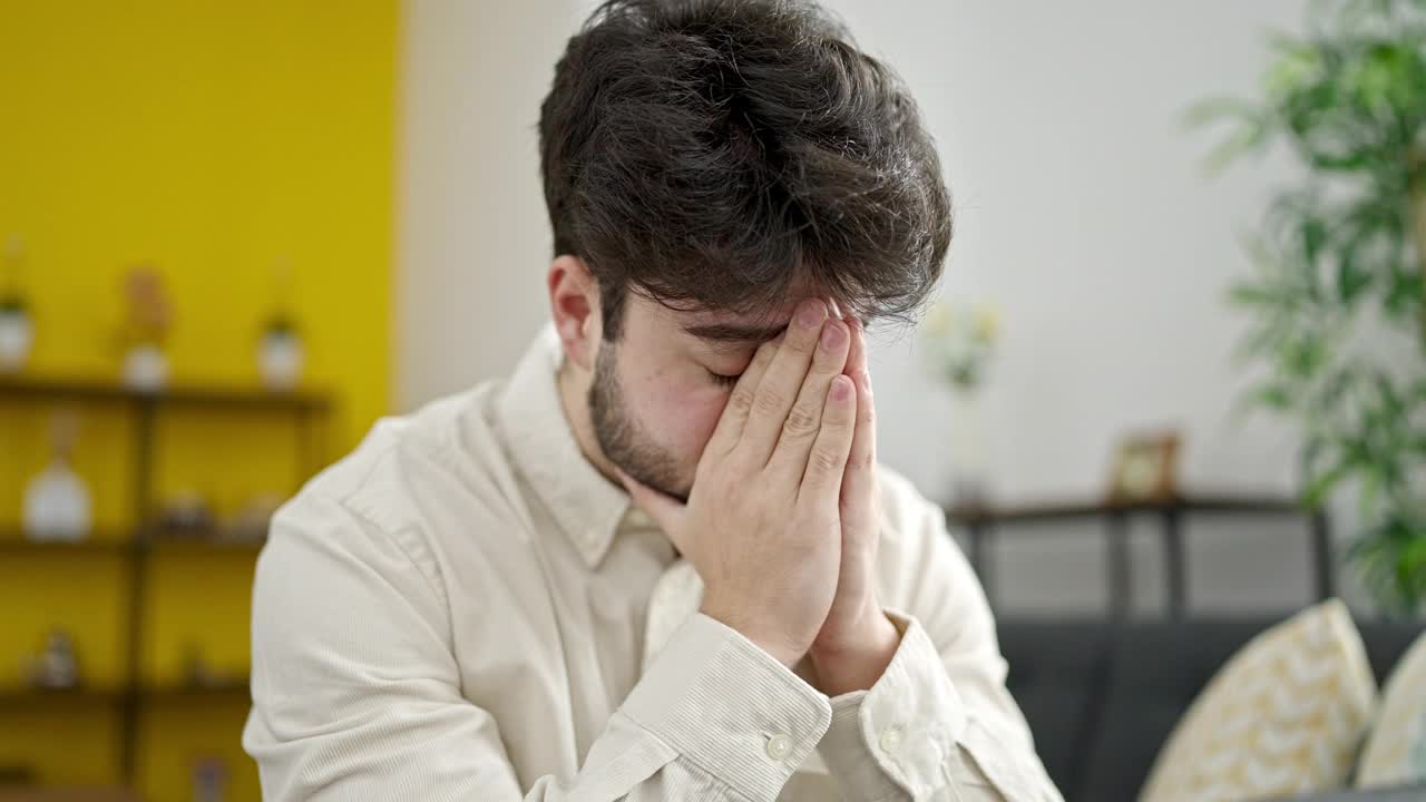 年轻的西班牙人坐在家里的沙发上视频素材