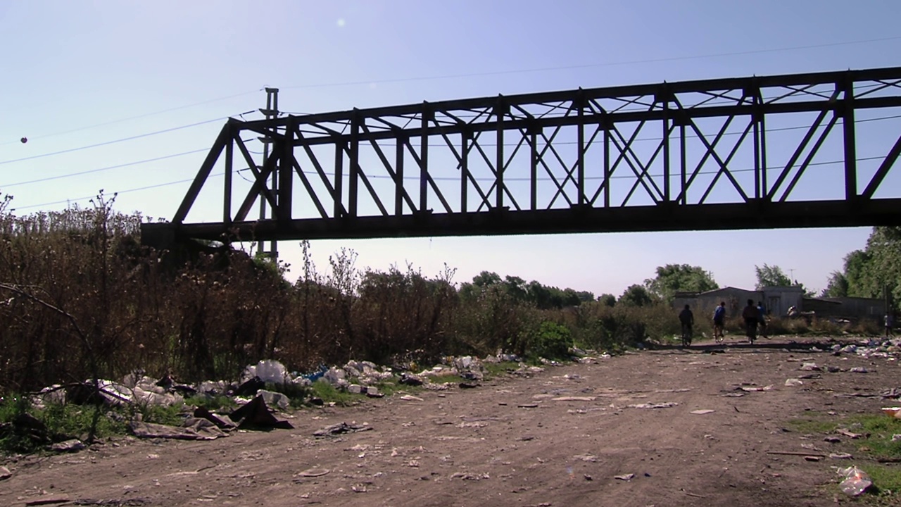 阿根廷布宜诺斯艾利斯省拉普拉塔市“Barrio Puente de Fierro”(铁桥社区)的老铁路桥对着太阳。视频素材
