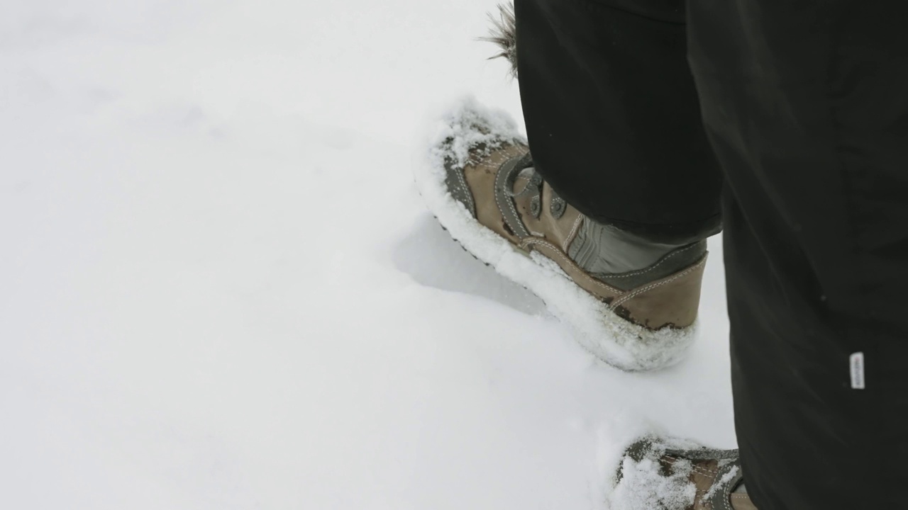 徒步旅行的人的腿走在雪地上的脚印，慢动作视频素材