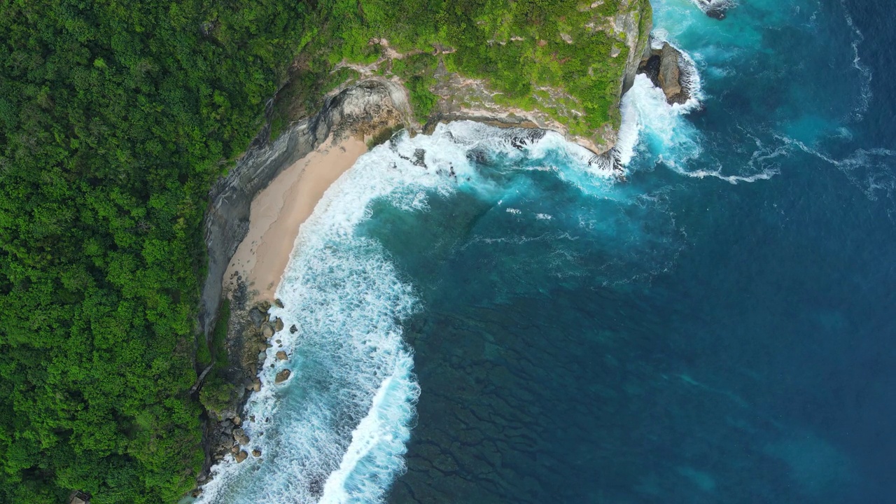 景观有海岸线、沙滩、风景秀丽的岩石和蓝色的海浪。鸟瞰图。视频素材