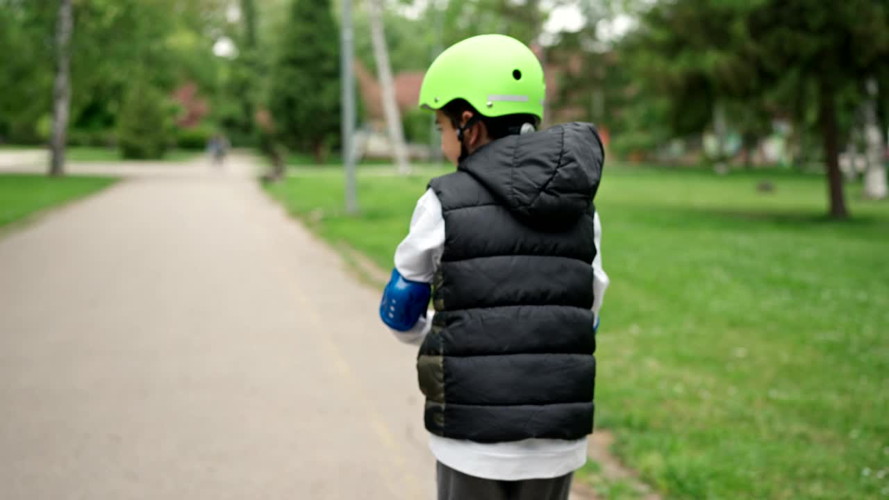 小男孩在公园里骑摩托车视频素材