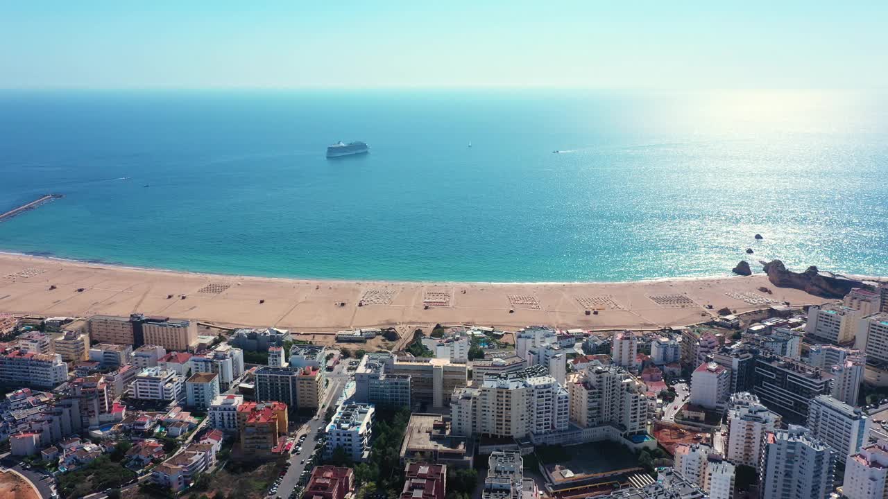 阳光明媚的一天，葡萄牙旅游城市波尔蒂毛的鸟瞰图。南葡萄牙阿尔加维。罗查海滩和班轮视频素材