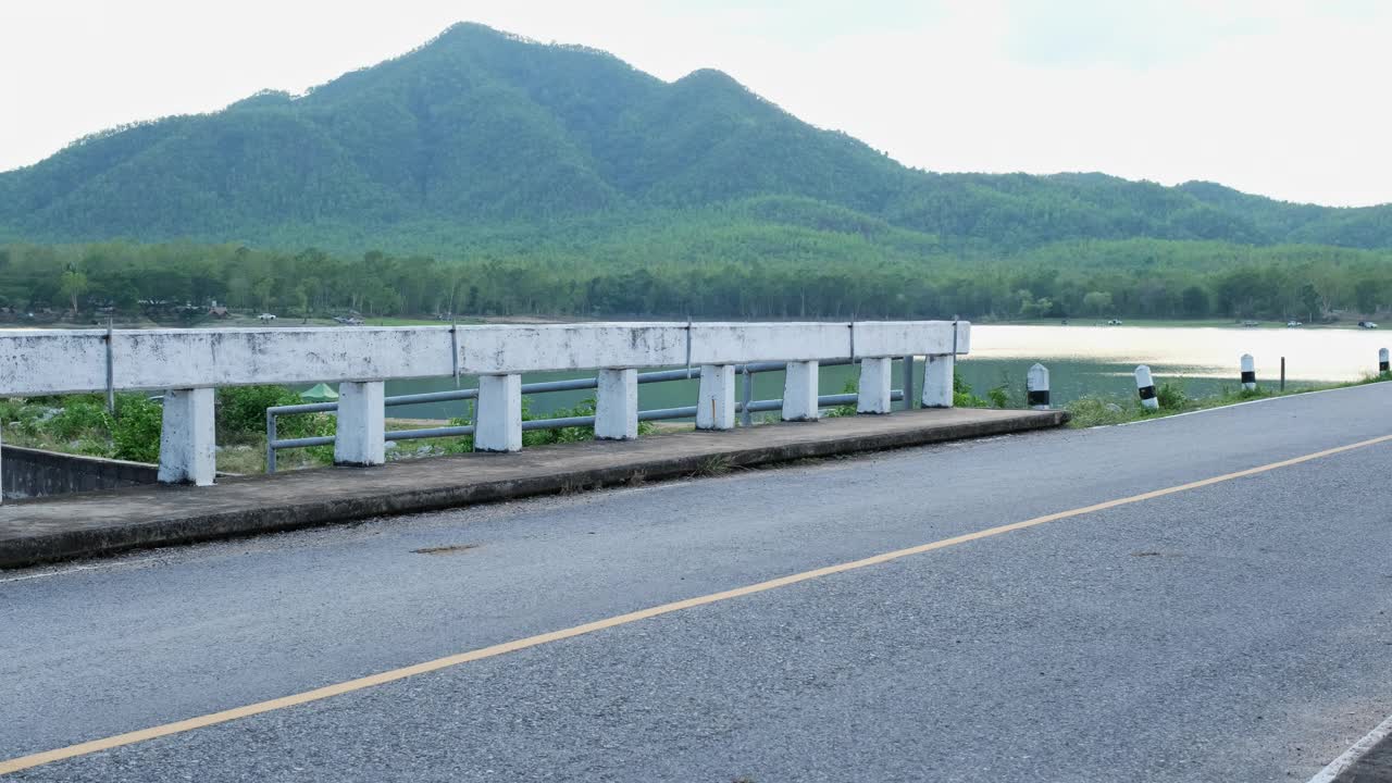 两个可爱的小女孩在夏季公园的户外道路上骑着滑板车视频素材