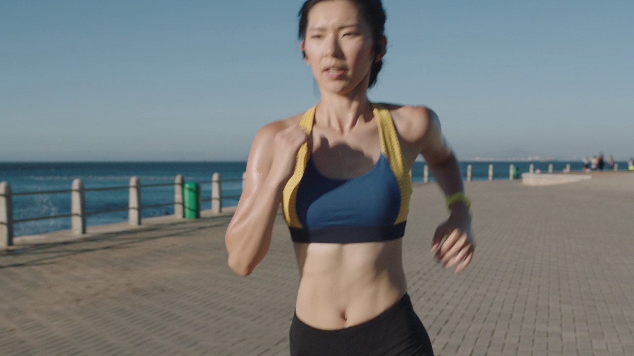 美丽的年轻亚洲女子跑步训练有氧运动享受健身锻炼的生活方式在清晨海边穿着运动服视频素材