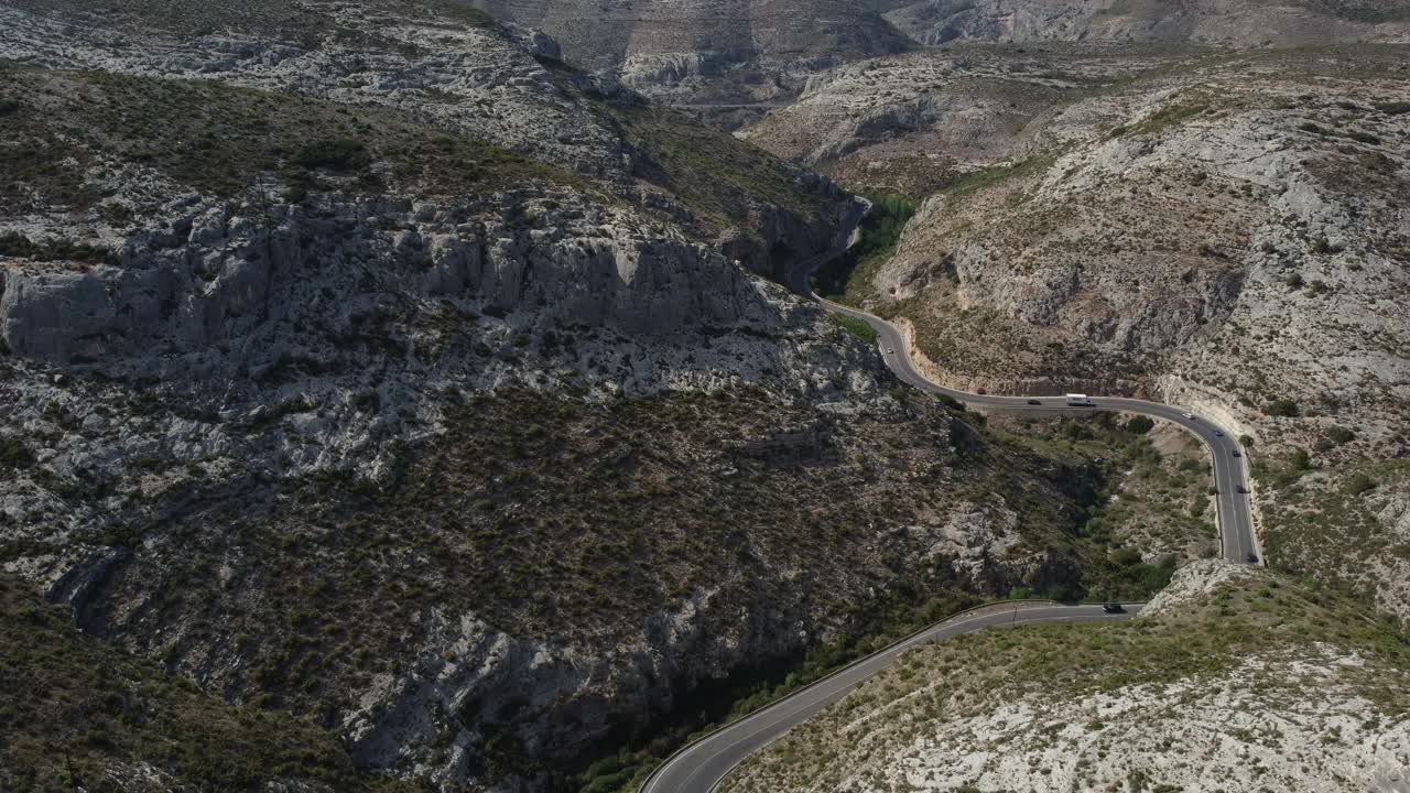 鸟瞰图，汽车和卡车行驶在弯曲的山路上。视频素材