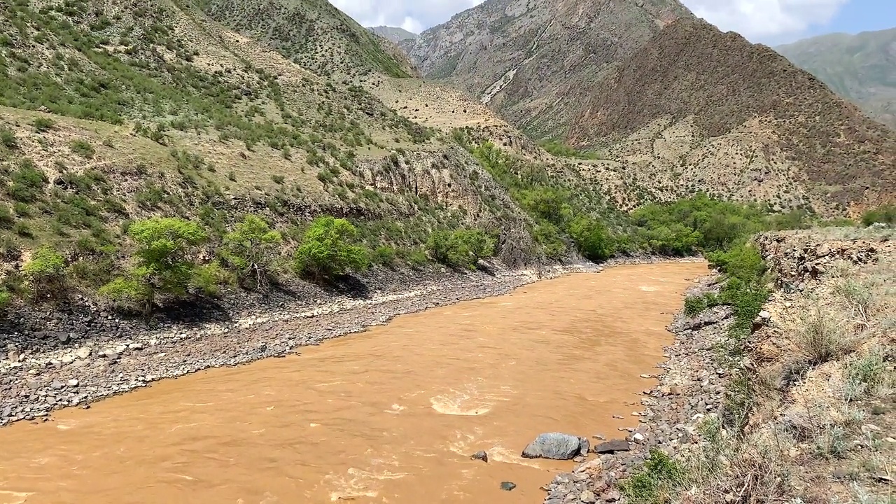 一个美丽的山谷全景，有一条肮脏的棕色暴雨河。令人惊叹的山地景观。视频素材